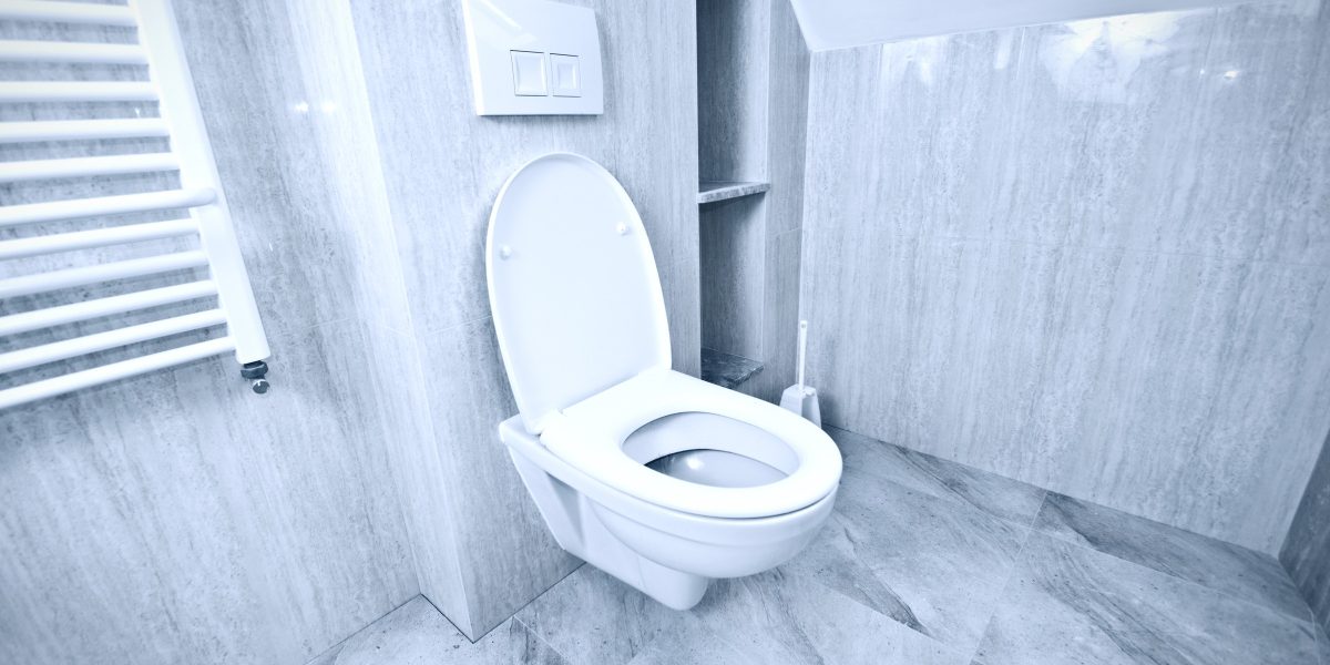 Cuvette de WC suspendue blanche dans une salle de bain carrelée