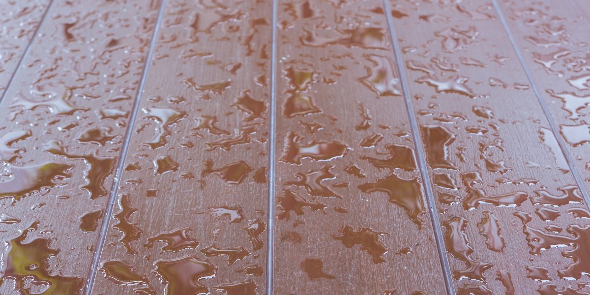 Parquet en bois couvert d'eau, flaques et reflets